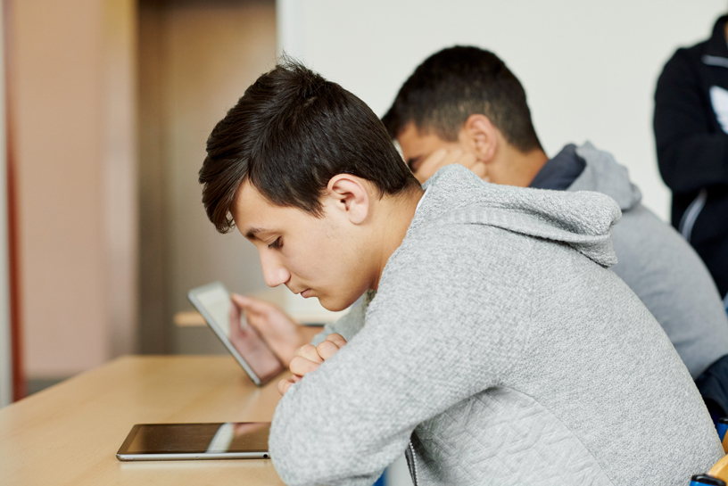 Mohammed Ibrahim looking at an iPad at his desk.