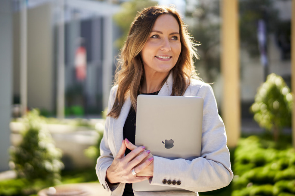 Jackie French of TAFE Queensland holding MacBook Air.