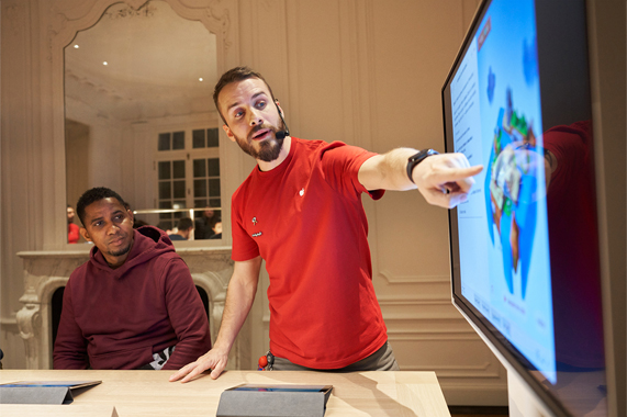 An Apple team member showing a customer a demo.
