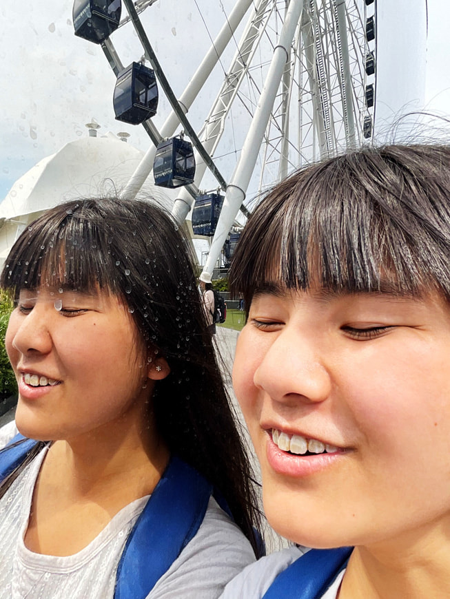 A self-portrait of Alaula Sprecher taken in front of a Ferris wheel at Navy Pier in Chicago.