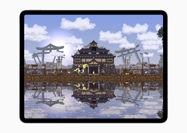 On iPad Pro, a still from the game Kingdom Two Crowns shows a house next to a body of water.