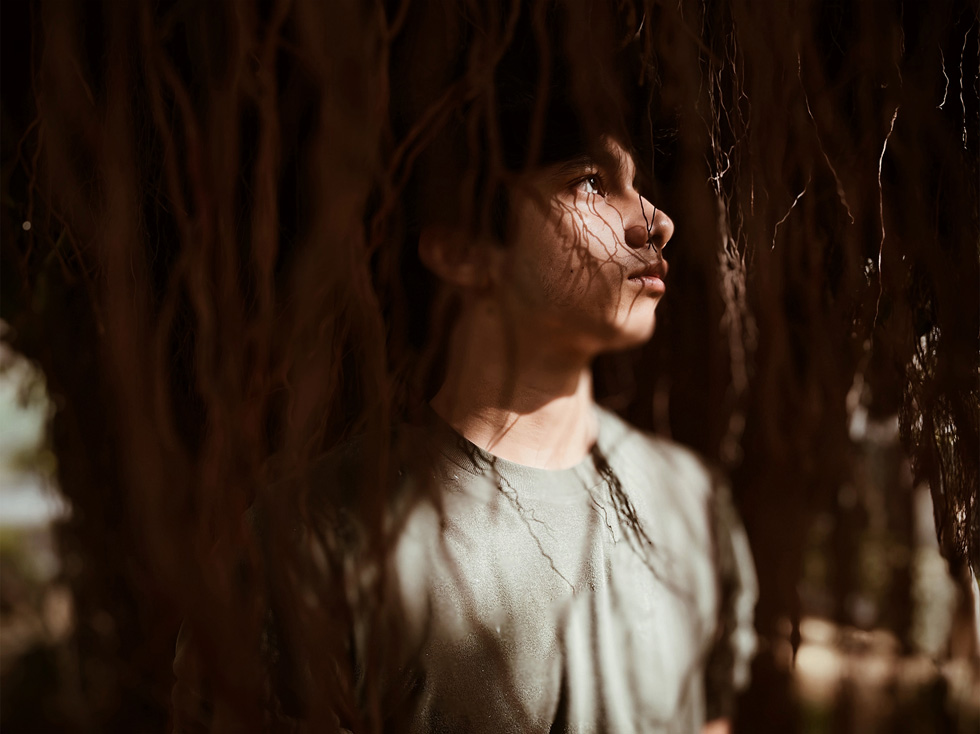 Light and shadow linger on a boy’s face.