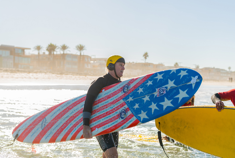 Leason heads out into the water with his custom Hank Warner competition surfboard.