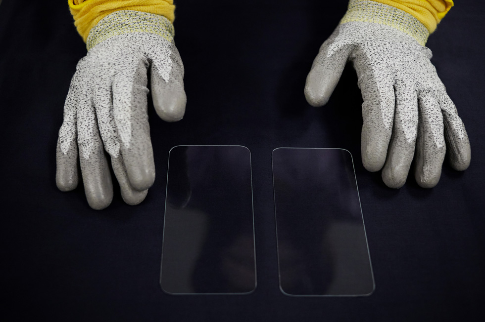 Gloved hands display new front covers for the iPhone 12 lineup.
