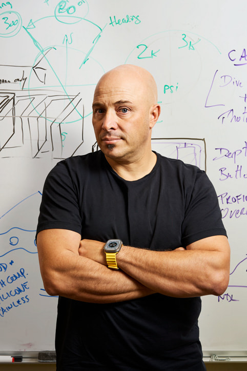 Huish Outdoors의 제품 개발 및 설계 담당 부사장인 안드레아 실베스트리가 화이트보드 앞에 서 있는 모습.  