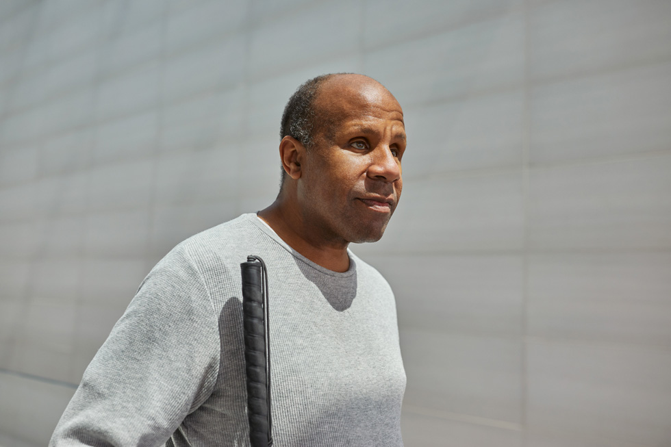 흰 지팡이를 짚고 있는 딘 허드슨.