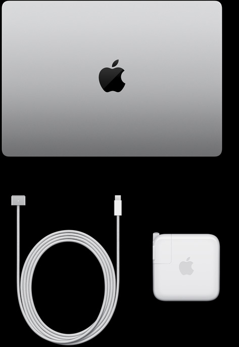 MacBook Pro, silver color, top, closed, next to charging cable and adapter
