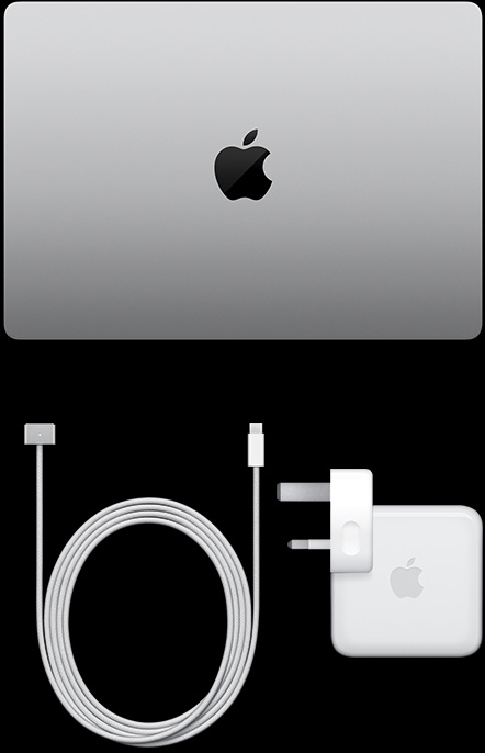MacBook Pro, silver color, top, closed, next to charging cable and adapter