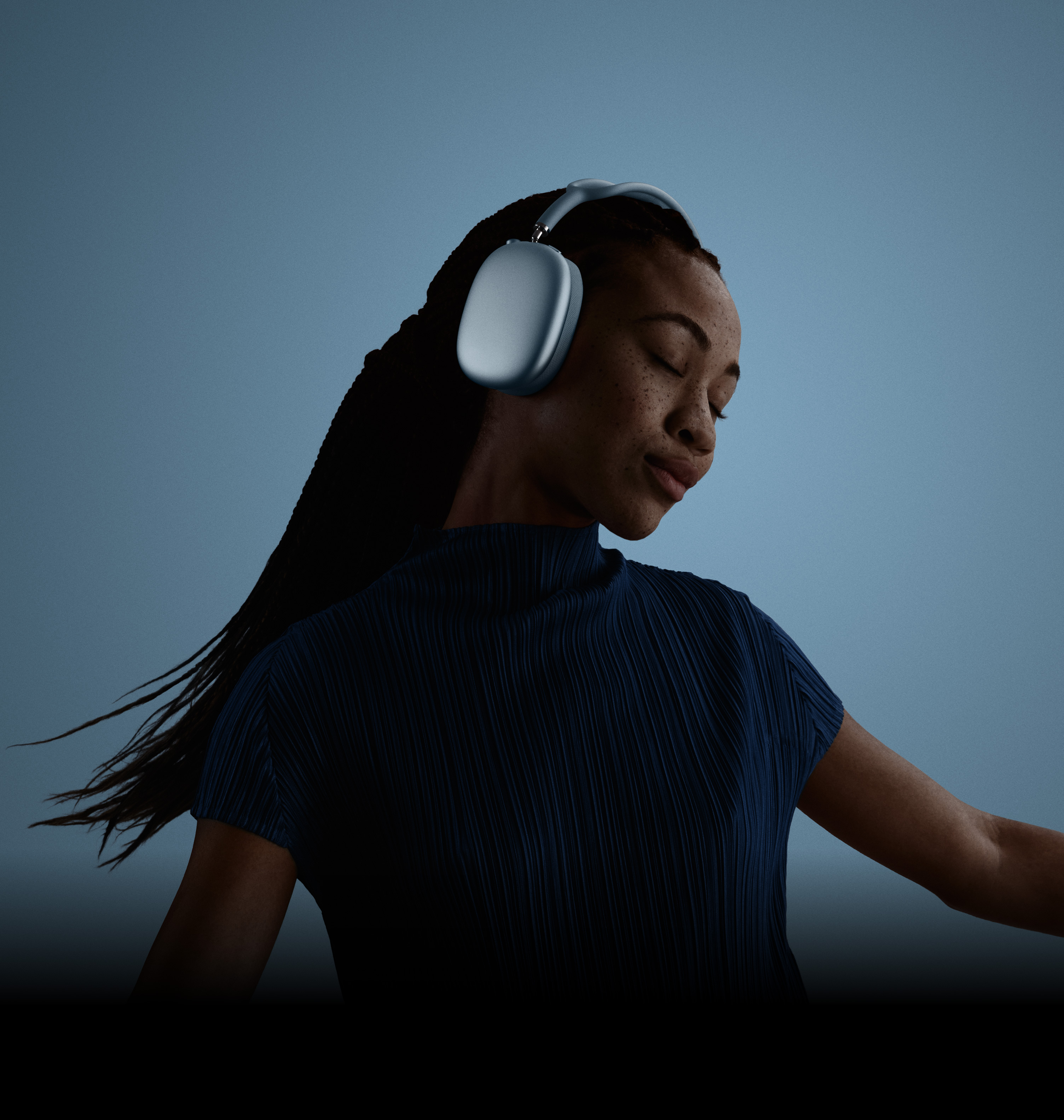 Başını sola eğmiş, gözleri kapalı, AirPods Max takmış bir kadın.