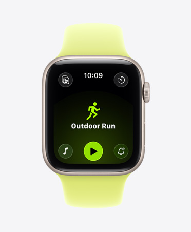 Apple Watch SE 3 com caixa em alumínio luz das estrelas, treino de Corrida (ar livre), controlos de reprodução da Apple Music na parte inferior do ecrã e Bracelete desportiva amarelo-néon