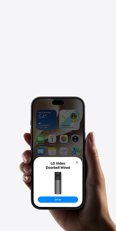 A hand holding an iPhone showing the Home app with a smart home accessory setup prompt