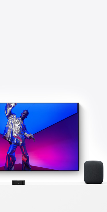 Apple TV 4K and HomePod, midnight color, TV screen shows a performer in a metallic silver outfit