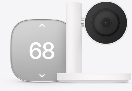 Apple Home Collection smart home thermostat, silver color, displaying temperature of 68 degrees, Apple Home Collection smart home camera, black lens and surround mounted on a white stand and arm