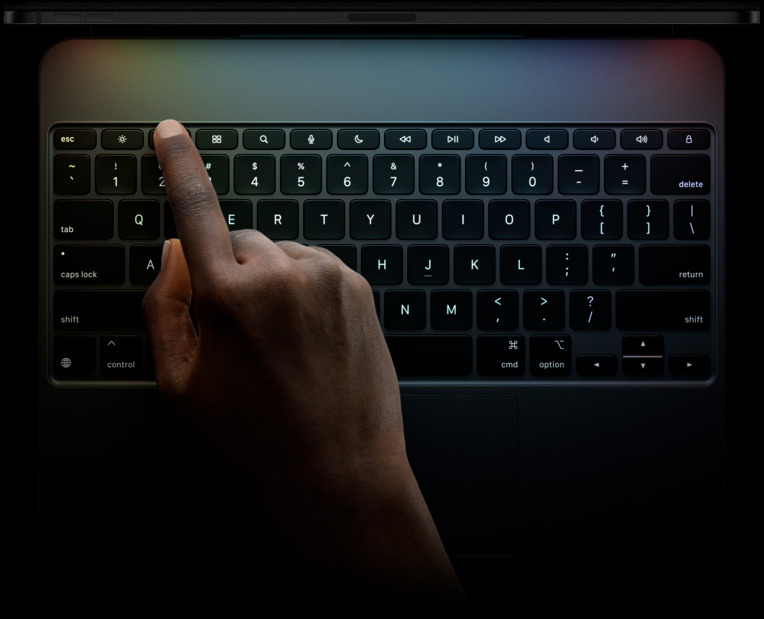 iPad Pro, landscape orientation, space black colour, top edge profile, attached to Magic Keyboard, front exterior, landscape orientation, black colour, backlit keys, dedicated function key row, escape, tab, caps lock, shift, control, option, shift, delete, return, inverted-T arrow keys, built-in trackpad