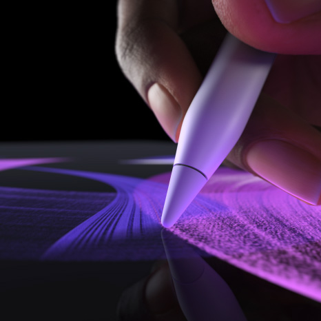 Apple Pencil Pro, parte lateral, color blanco, una mano sostiene el lápiz y dibuja un trazo de color azul intenso