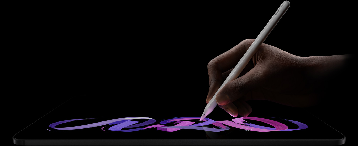 iPad Pro, parte frontal, posición horizontal, parte lateral, negro espacial, una mano sostiene un Apple Pencil Pro color blanco y dibuja un diseño abstracto en morado y rosa sobre la pantalla