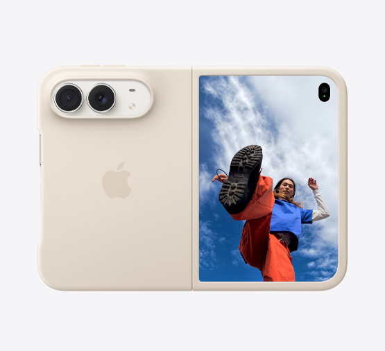 iPhone Duo, Farbe Sternenweiß in Silikon Case in Sand, Querformat, vollständig geöffnet, Dual Fusion Kameras oben links, Case bedeckt die Rückseite und den äußeren Rand des vorderen Displays, die rechte Seite mit äußerem Display mit dem Bild einer Person, die unter einem wolkenbedeckten blauen Himmel steht