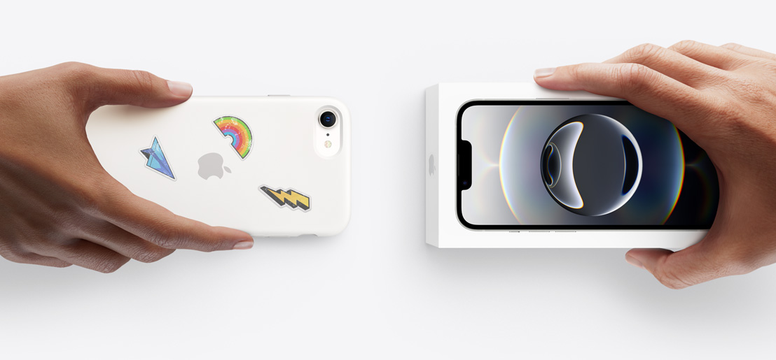 Dos manos intercambian un iPhone 16e con funda de silicón y stickers en la parte posterior por un iPhone 17 nuevo en su caja.