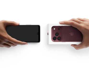 Hands exchanging phones, Android on the left without a box, on the right is a new iPhone 17 Pro  in box