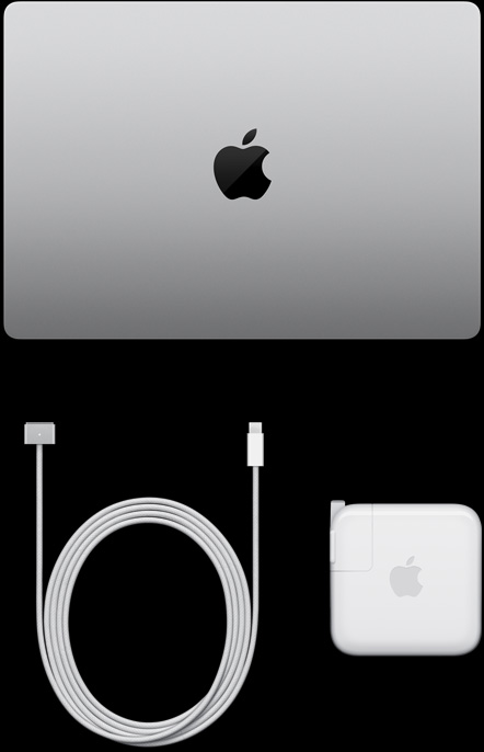 MacBook Pro, silver color, top, closed, next to charging cable and adapter