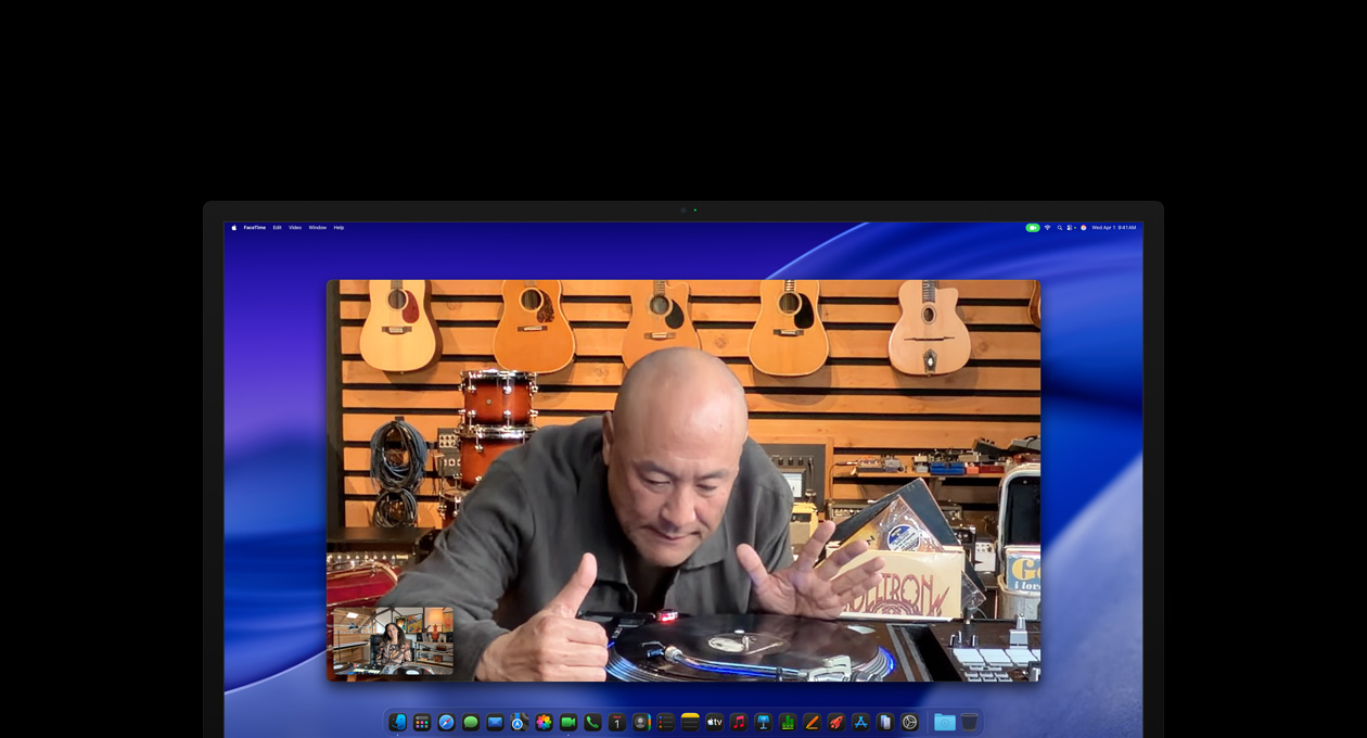 While on a video call, a person at a music store looks closely at a turntable, he remains centred in the frame thanks to the Center Stage camera