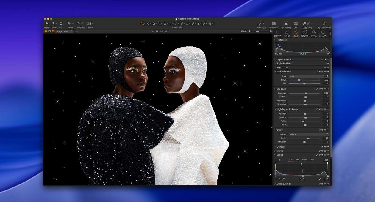 Egy fekete és egy fehér ruhás ember egymással átellenben áll, bemutatva a Studio Display XDR fényerejét és kontrasztját