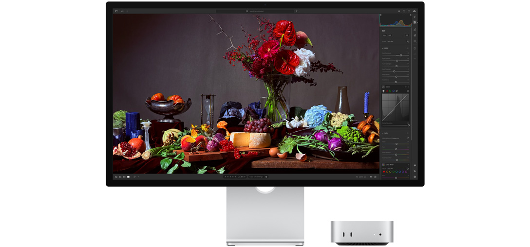 Imagem em alto contraste de uma mesa com vários pratos de comida e um buquê sobre um fundo escuro, mostrando como o True Tone ajusta a temperatura das cores.