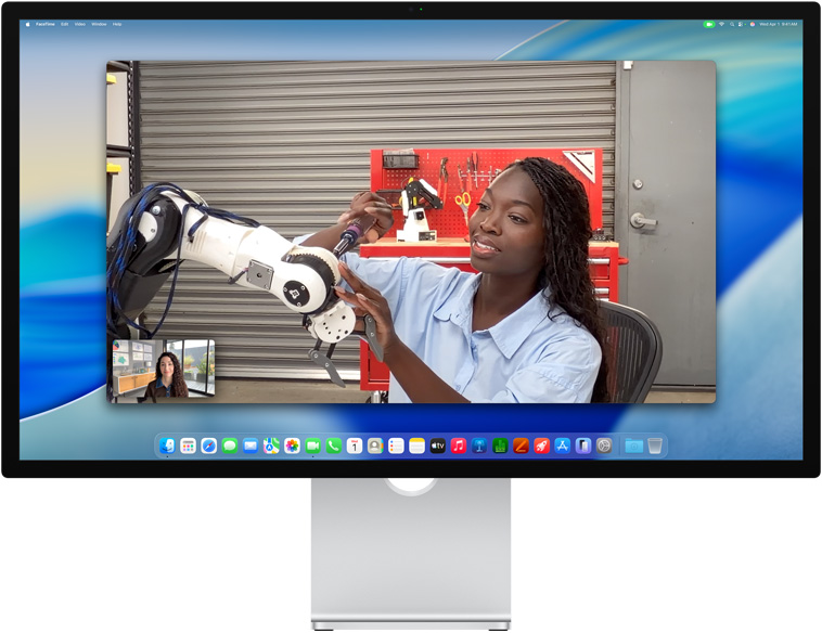 Two people on a video call on Studio Display, Center Stage keeps them centred in the frame even as one person moves to repair a piece of equipment