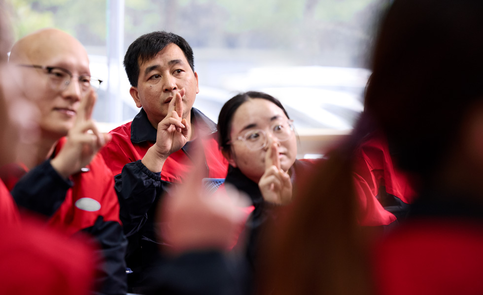 Several people sign in unison as they look in the same direction