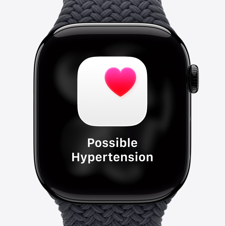 Apple Watch Series 11, aluminium case, polished Jet Black colour, possible hypertension health notification, pink heart in white box, right side exterior, Digital Crown, Sport Band, black colour